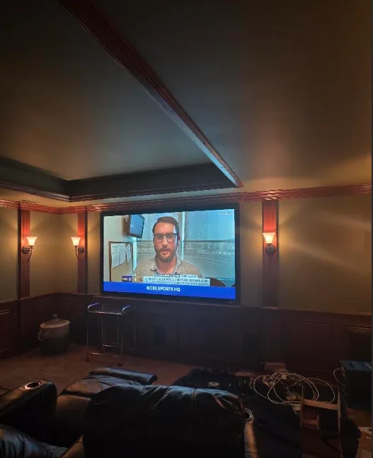 Professional home theater installation with projector and surround sound speakers
